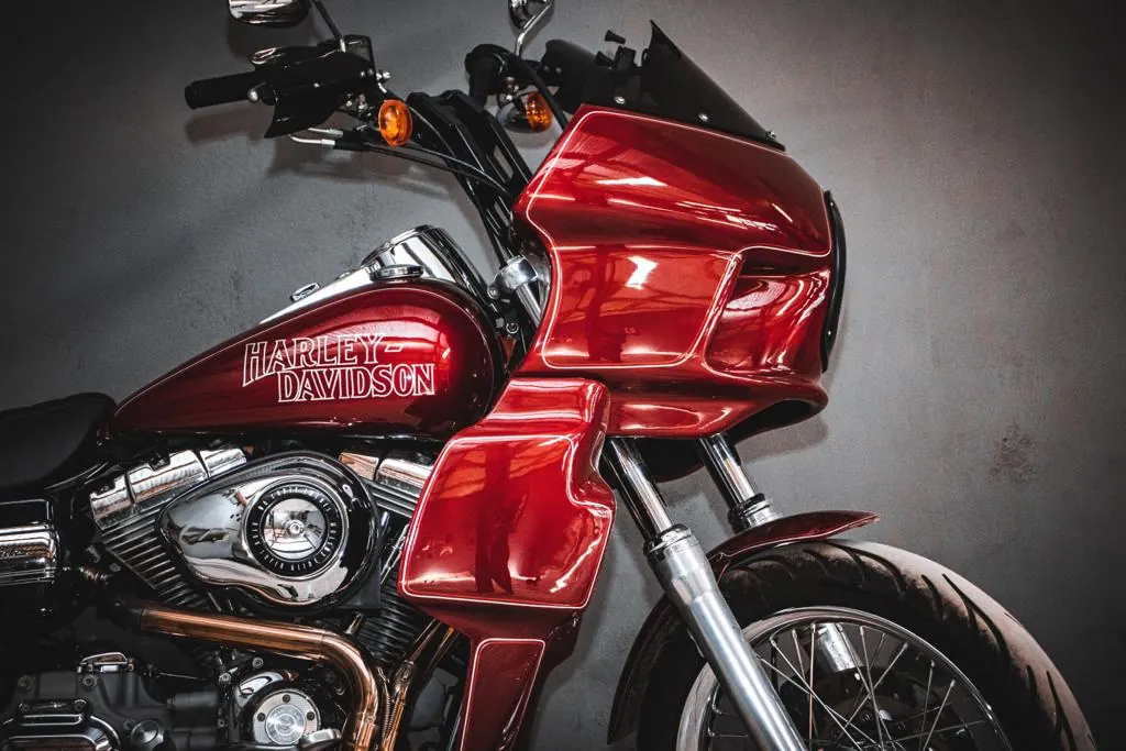 Detalhe frontal do fairing vermelho instalado em uma Dyna