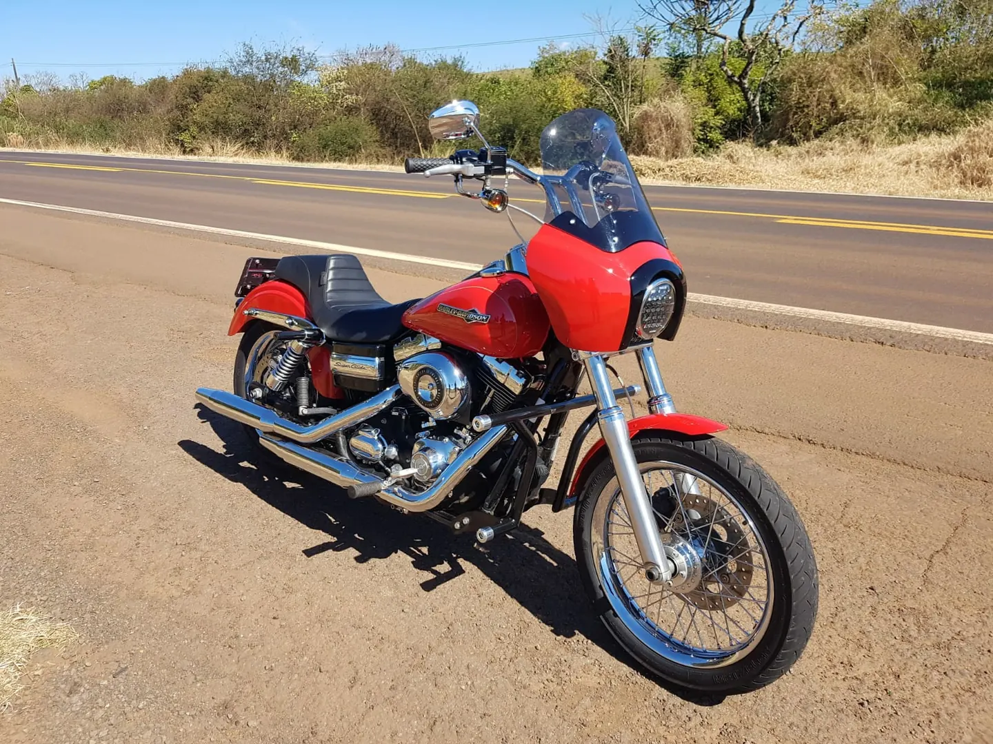 Dyna vermelha com fairing alto em vista lateral
