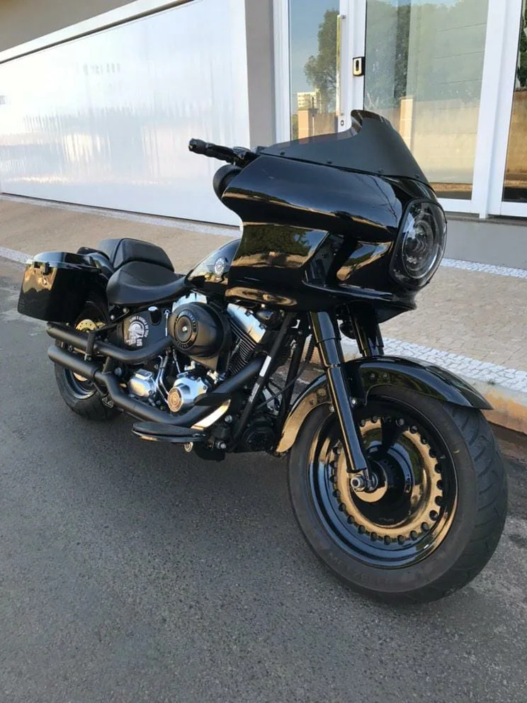 Fat Boy preta com fairing FXRT em ângulo frontal de três quartos
