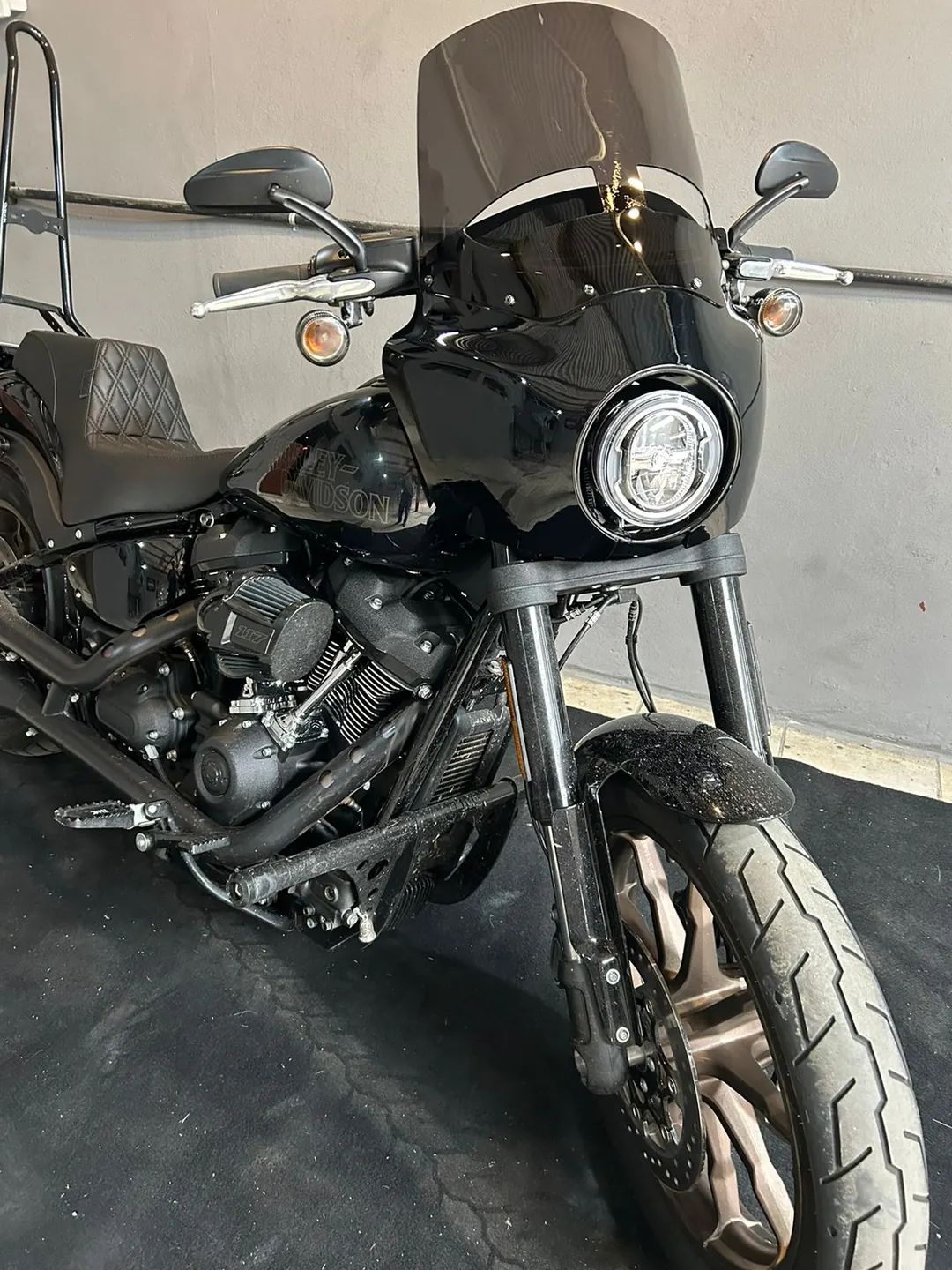 Vista frontal da Low Rider S com fairing e farol redondo