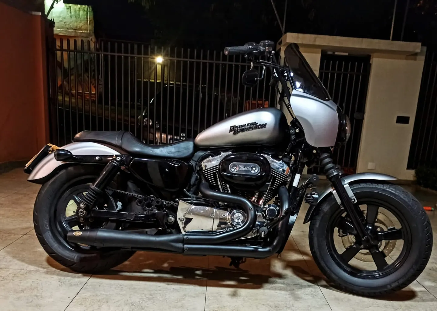 Sportster com fairing T-Sport em vista lateral noturna